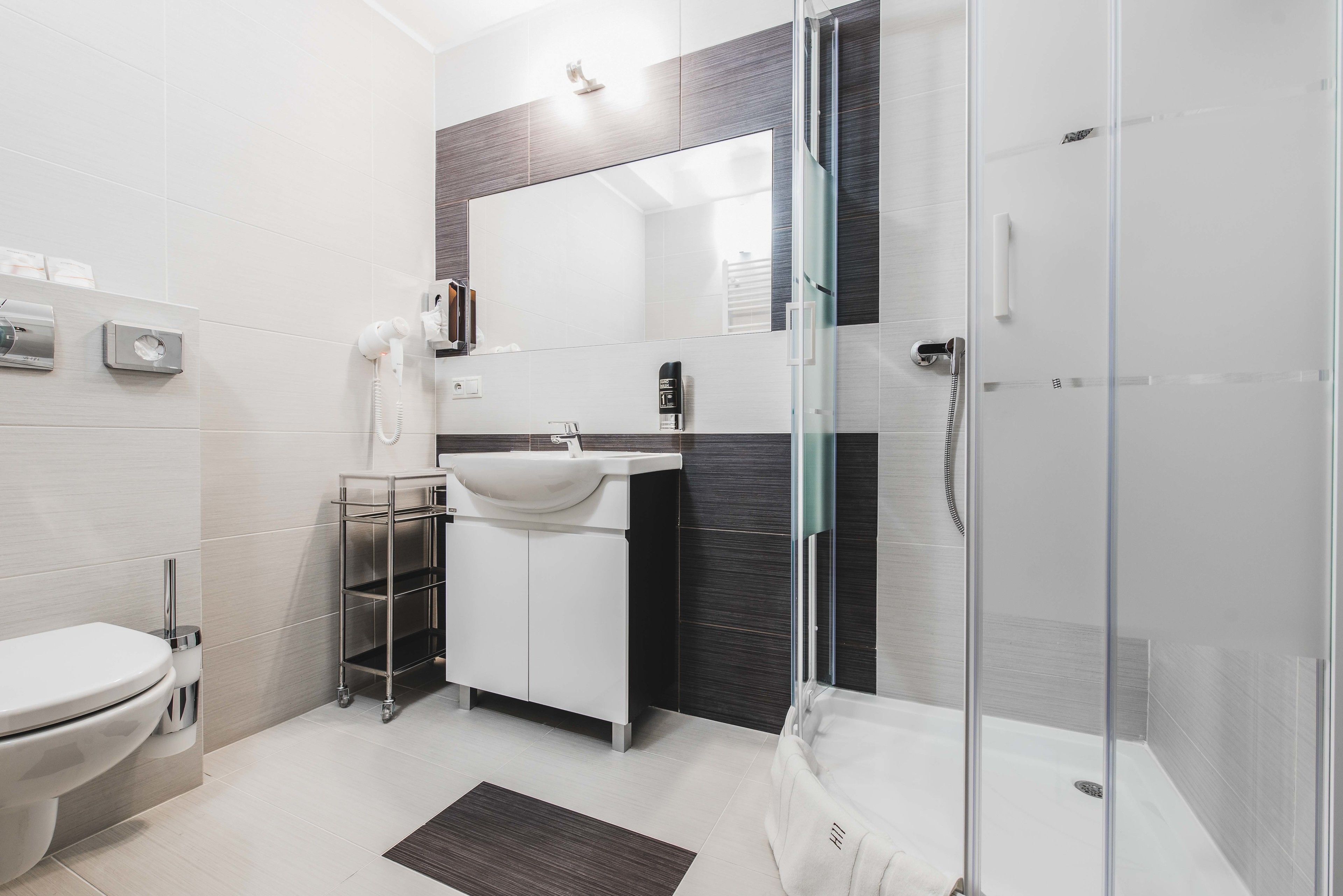 A modern bathroom with a toilet, sink, and shower.