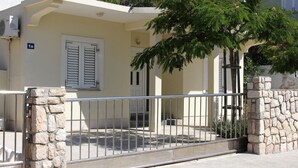 A residential building with a stone gate, a white door with shutters, and a number sign '1a'.