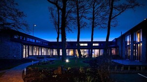 A modern building with a courtyard, large windows, and a well-lit entrance. - 315 Bar And Restaurant (Huddersfield)
