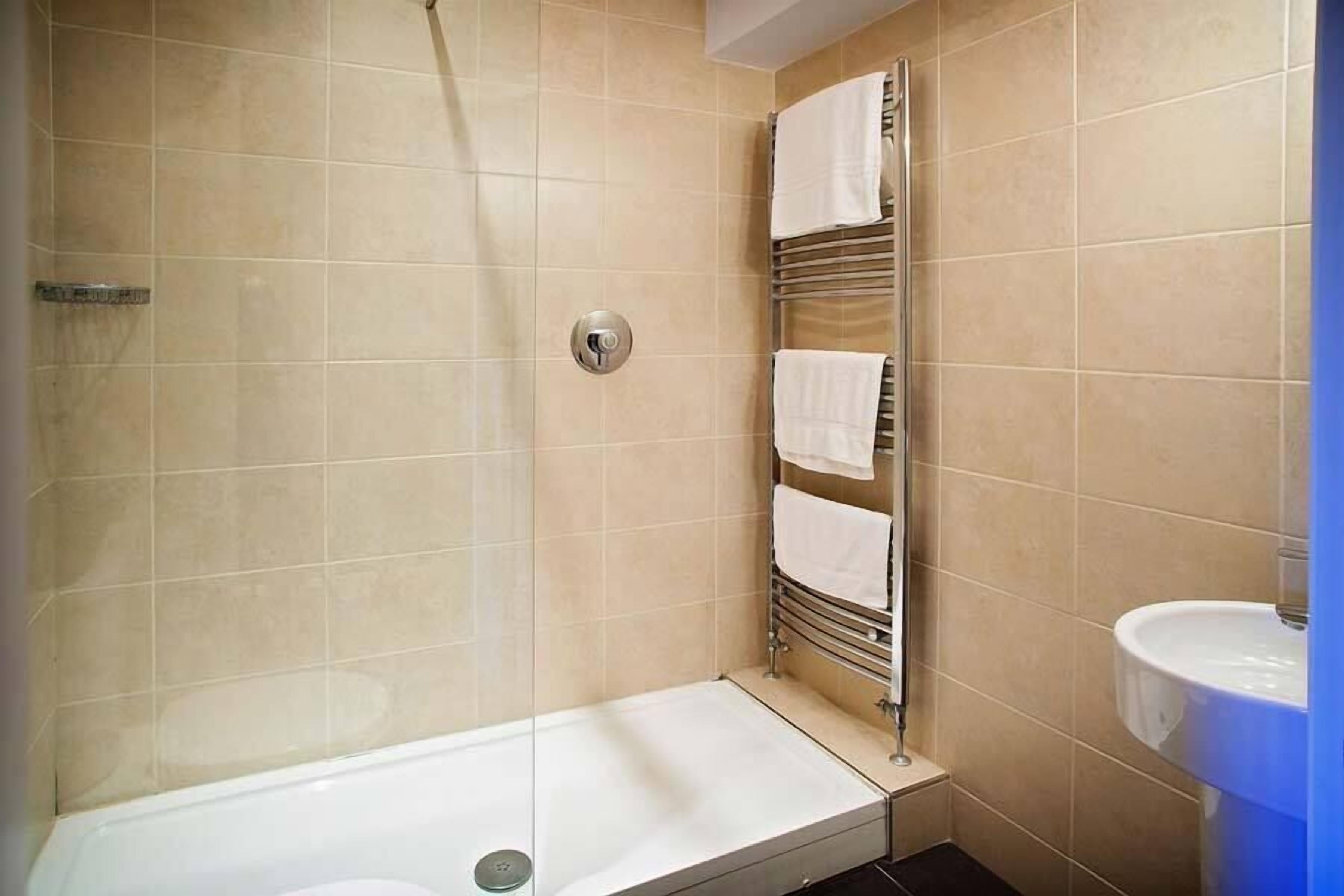 A bathroom with a shower, a bathtub, and a sink.