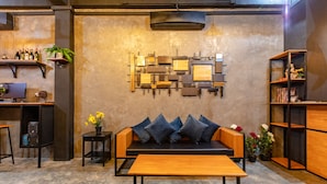 Un interior moderno con un sofá, una mesa de madera y una lámpara fijada a la pared.
