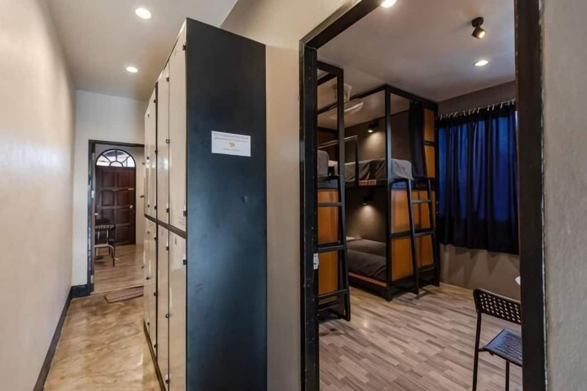 Una habitación de hotel con armario, cama, escritorio y silla.