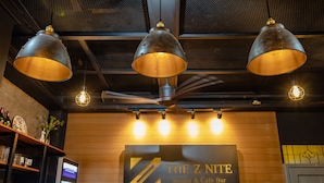 Señalización de 'The Z Nite Hostel & Cafe Bar' con tres lámparas colgantes.