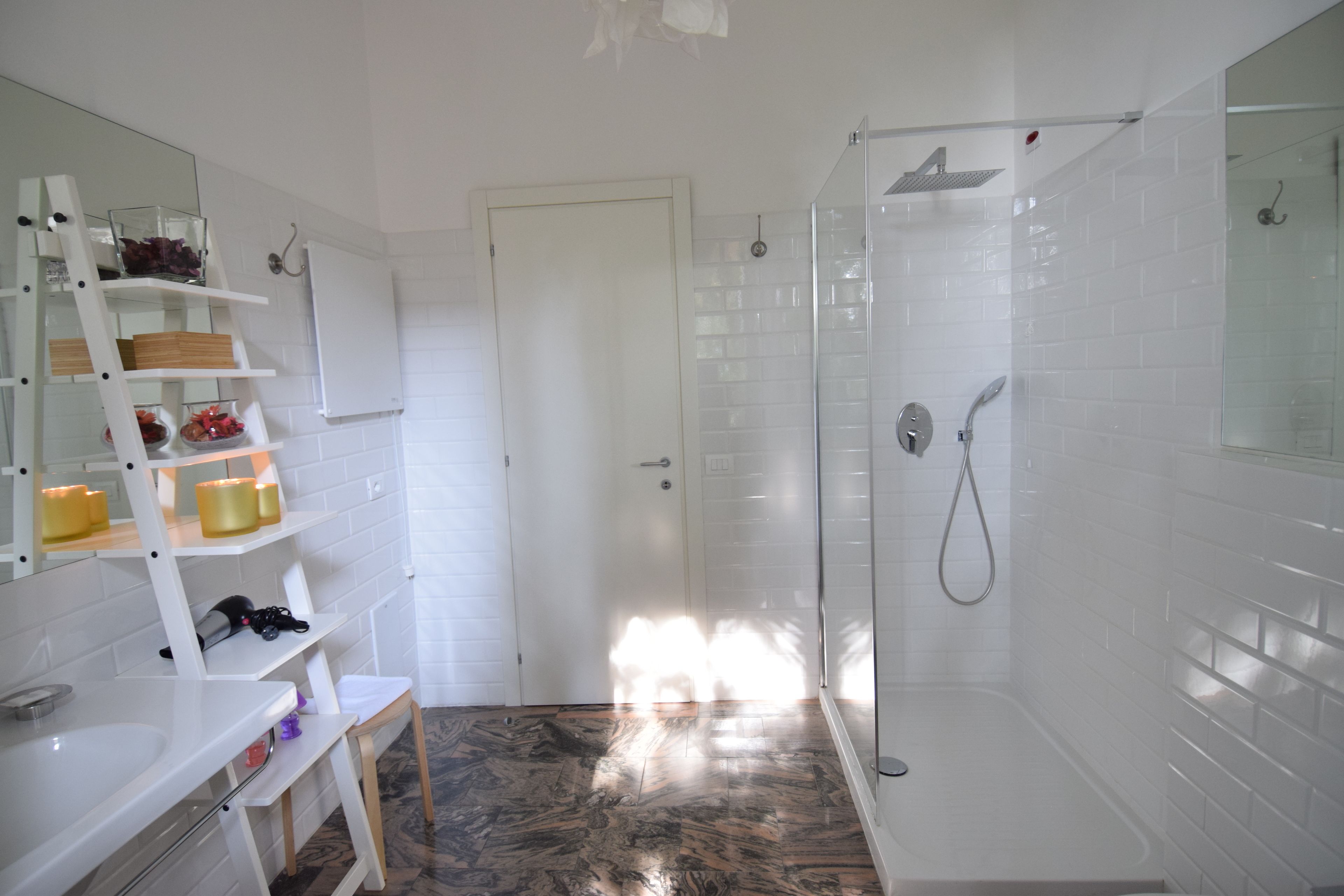 A bathroom with a shower, a sink, and a mirror.