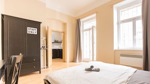 A hotel room with a bed, a desk, a wardrobe, and a bathroom visible through an open door. - Premier Apartment near Museum (Prague)