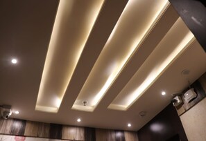 A ceiling with recessed lighting and a security camera. - Hotel Angina (Kolkata)