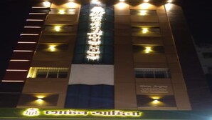 A hotel with a vertical sign in a foreign language, multiple illuminated windows, and a sign indicating "Hotel Angina." - Hotel Angina (Kolkata)