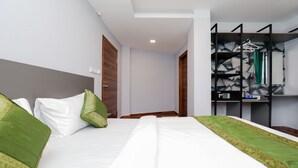 A hotel room with a bed, a wardrobe, and a mirror. - Treebo Apple Villa (Bengaluru)