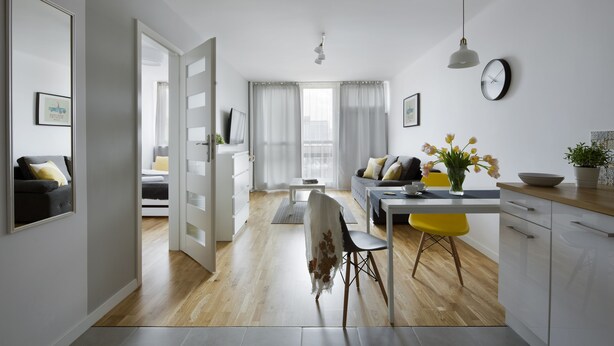 Un espace de vie et de salle à manger moderne, à aire ouverte, comprenant une cuisine, une table à manger avec des chaises, un canapé et une table basse.