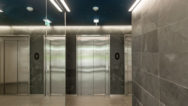 A modern elevator area with metallic doors and a clean, tiled floor.