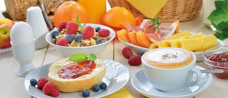 A breakfast setting with bread, fruits, cheese, and a cup of coffee.