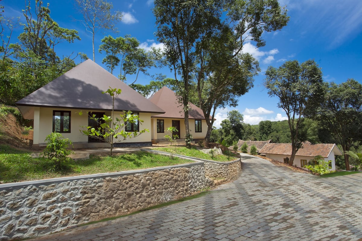 Zona residencial com casas, caminhos pavimentados e vegetação ao redor.
