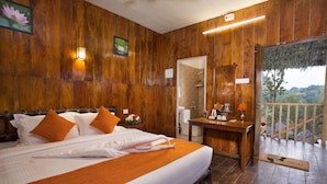 A wooden-themed bedroom with a bed, pillows, a nightstand, and a view of the outdoors. - Spices Lap Thekkady (Udumbanchola)