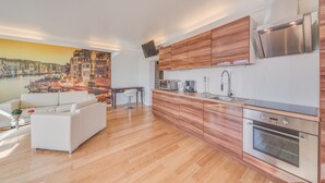 A modern kitchen with wooden cabinets, stainless steel appliances, and a cityscape mural on the wall. - Villa Rhenus (Ginsheim-Gustavsburg)