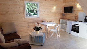 A cozy cabin interior with a wooden interior, a dining area, a kitchenette, and a sofa. - karsibor.de (Swinoujscie)