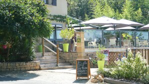 Un restaurante con terraza, una escalera de piedra y un cartel.