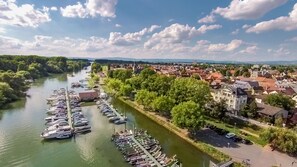 A riverside town with a marina, historic buildings, and a prominent church tower. - Apartmenthaus am Rhein (Ginsheim-Gustavsburg)