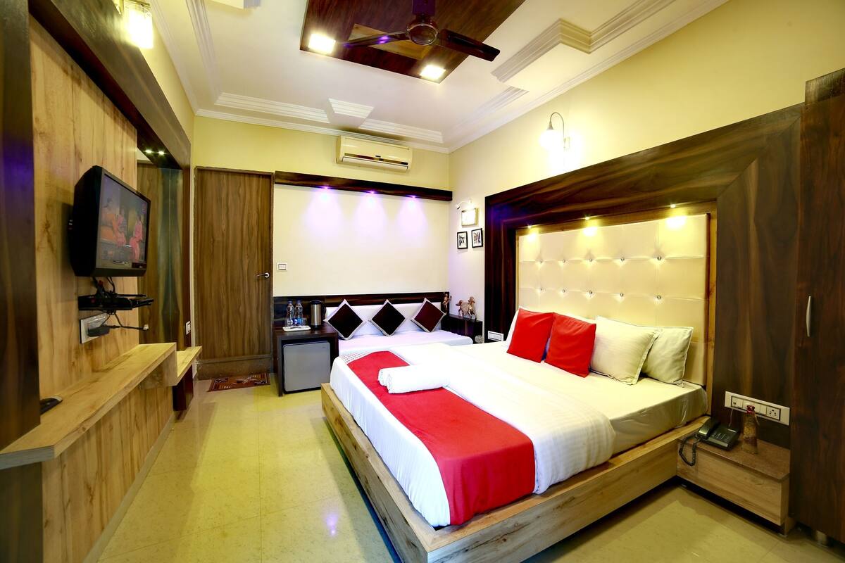 Une chambre d’hôtel avec un grand lit, une télévision, un bureau et une armoire.