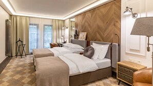 Habitación de hotel con dos camas, un panel decorativo de madera, un escritorio pequeño y una mesita de noche.
