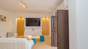 Una camera da letto moderna con un letto, una televisione, una vasca e un armadio.