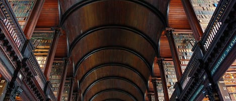 A library interior with multiple levels of bookshelves and a central spiral staircase.
