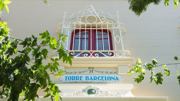 A building facade with a sign reading "TORRE BARCELONA" and ornate architectural details.