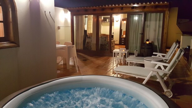 A hot tub in a covered outdoor area with lounge chairs and a dining table. - Luxury Loft in Gran Canaria. Jacuzzi and Free WIFI. (Sta Brígida)