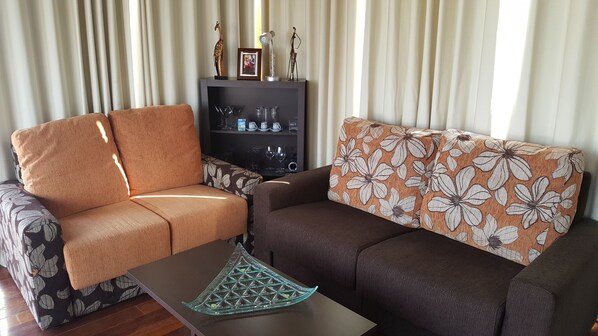 A living room with two sofas, a coffee table, and a cabinet with decorative items. - Luxury Loft in Gran Canaria. Solarium and Free WIFI. (Sta Brígida)