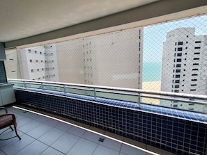 A balcony with a metal railing, tiled floor, and a chair. - Beach Class Residence by SOLEMAR (Fortaleza)