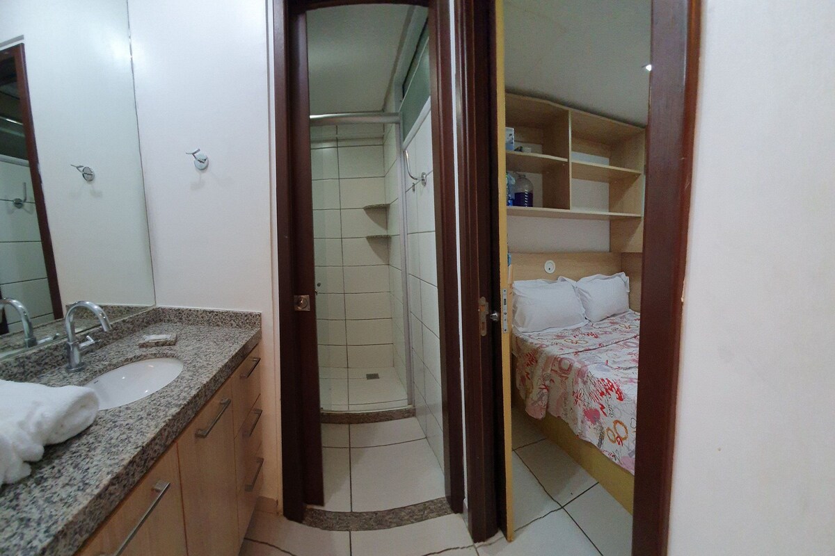 A bathroom with a sink, mirror, and shower.