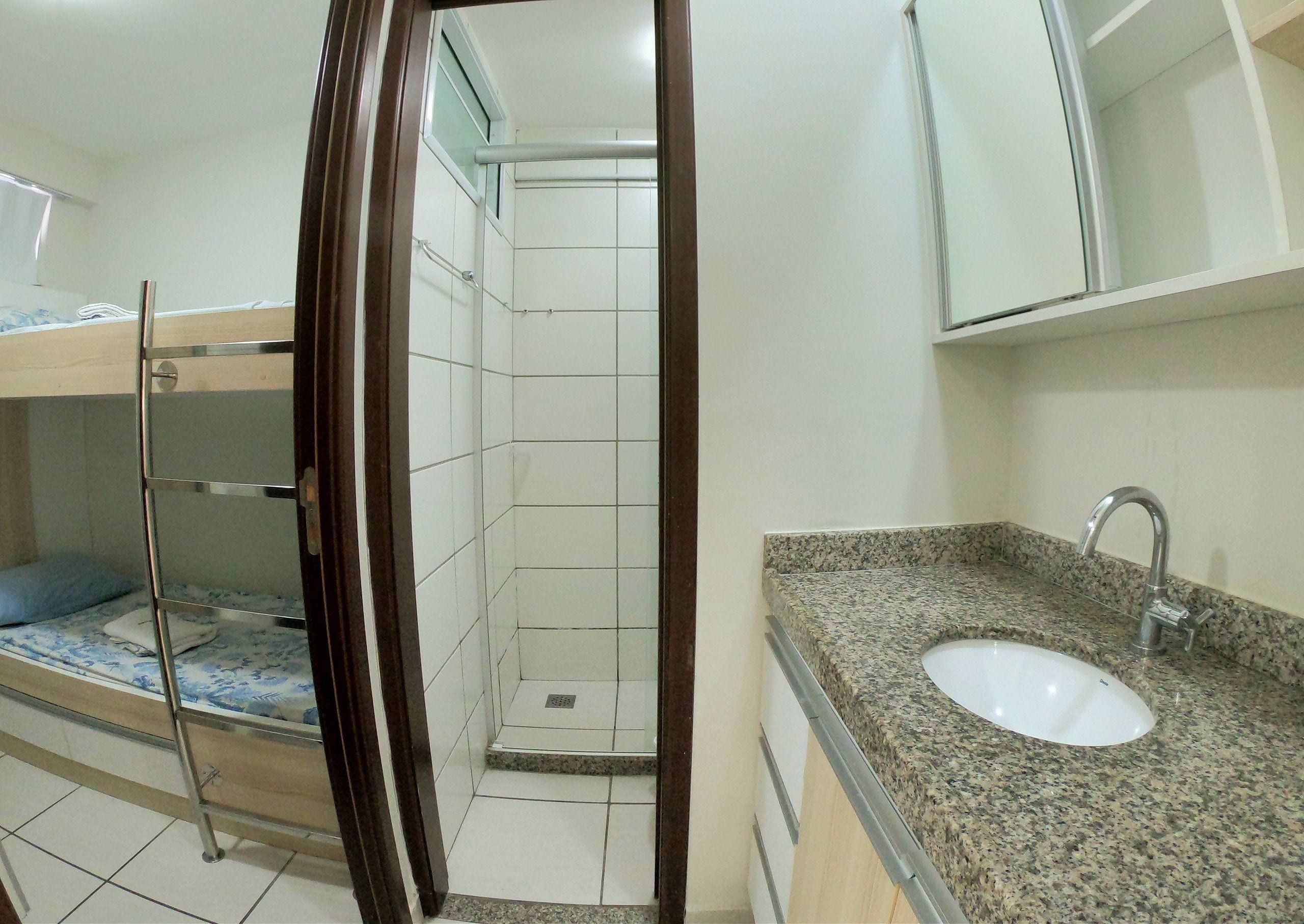 A bathroom with a sink, mirror, and shower.