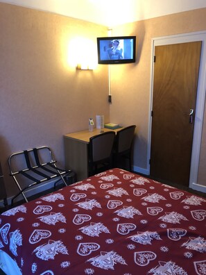 Escritorio, cortinas blackout y tabla de planchar con plancha