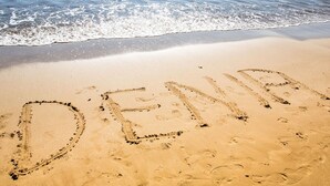 Una platja amb la paraula "DENIA" escrita a la sorra.