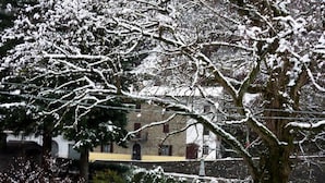 Een besneeuwde buitenruimte met een trap die naar een gebouw leidt.