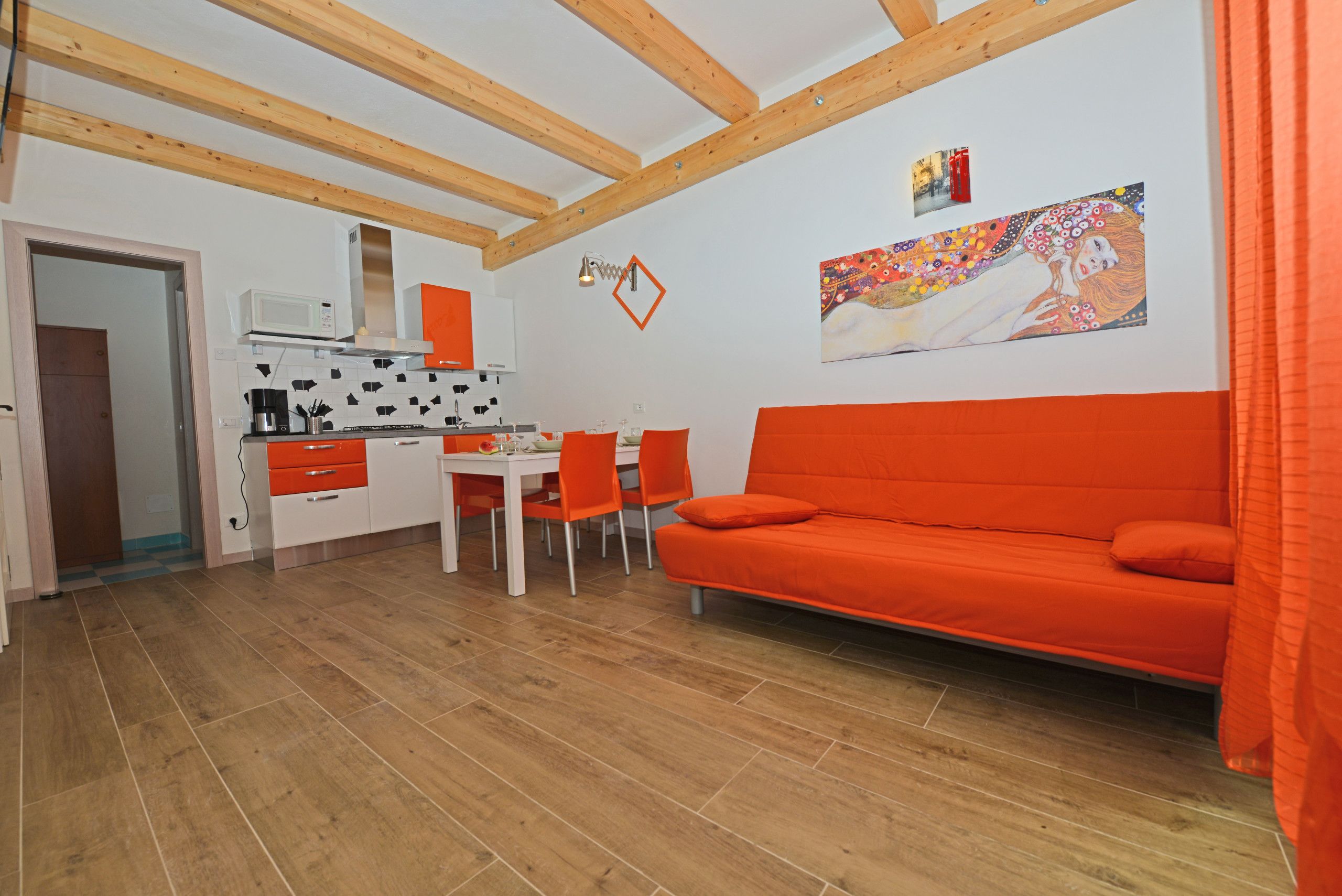 A compact living space with a kitchenette, a dining area, and a sofa.