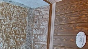 A room with a stone wall, wooden paneling, and a circular emblem on the wall.