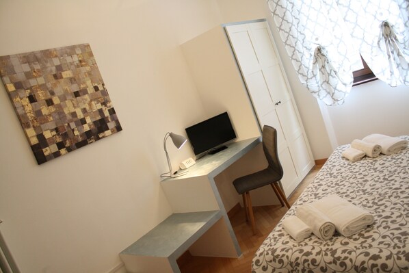 A bedroom with a bed, a desk with a computer, a chair, and a wardrobe. - Casa Mia - NO Reception (Trento)