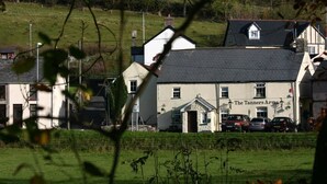 A building with a sign reading "The Tanners Arms" and several parked cars in front. - The Tanners Arms (Brecon)