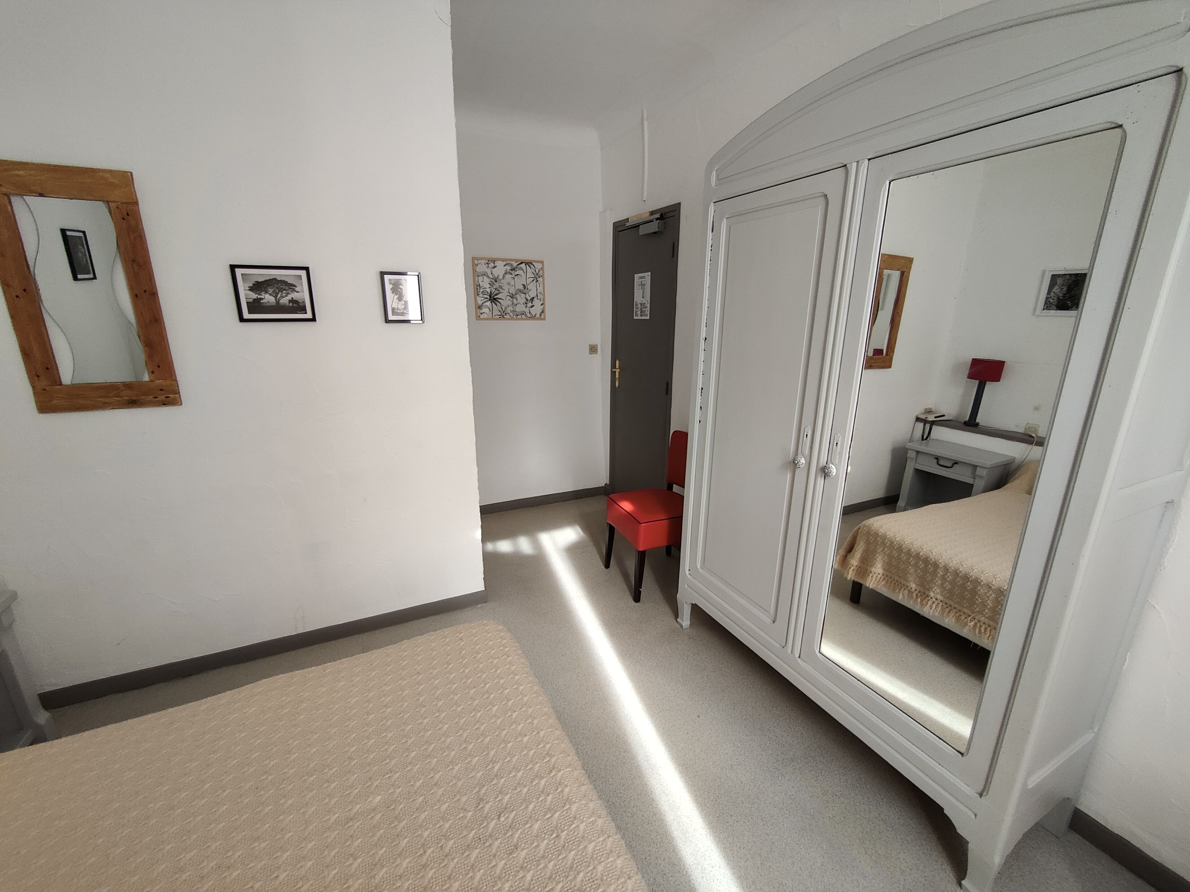 Un pasillo con una cama, un escritorio y una silla.