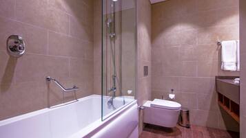 Ein modernes Badezimmer mit einer gläsernen Duschkabine, einer weißen Badewanne und Holzboden.