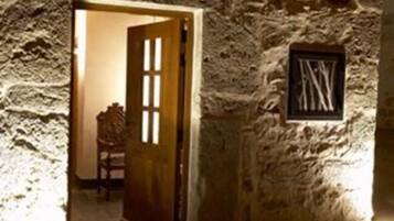A stone wall with a carved wooden door and a framed picture.