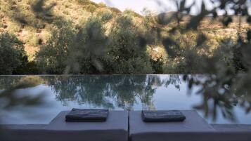 Een buitenzwembad, parasols voor strand/zwembad