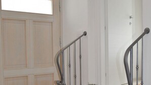 A staircase with a handrail, a potted plant, and a door with a window. - Casa del Borgo Maria Luisa (Tremosine)