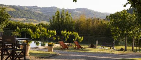 Un patio con mesa y sillas, un sendero de ladrillos y vistas a un paisaje montañoso.
