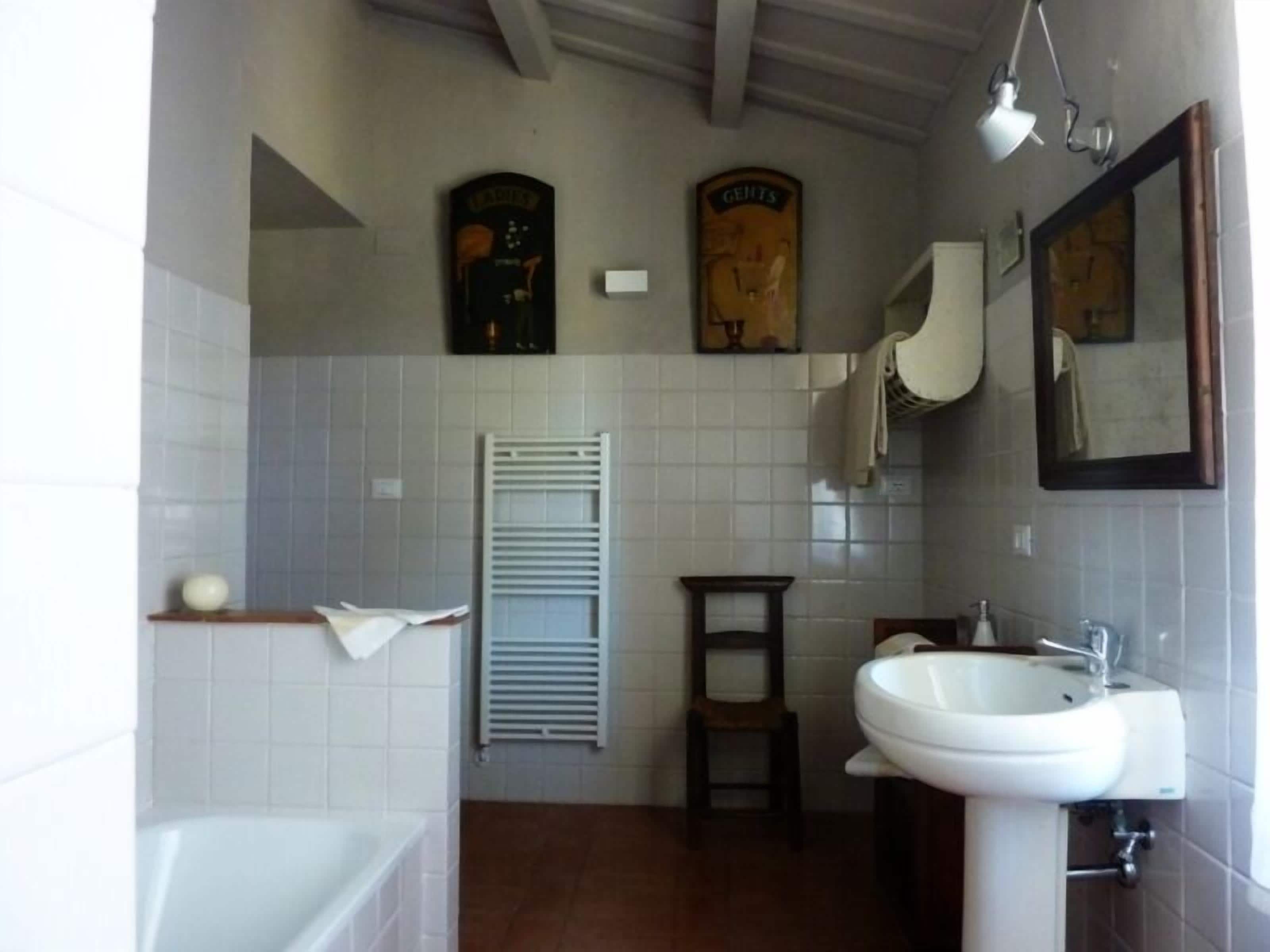 A bathroom with a white sink, a mirror, and a towel rack.