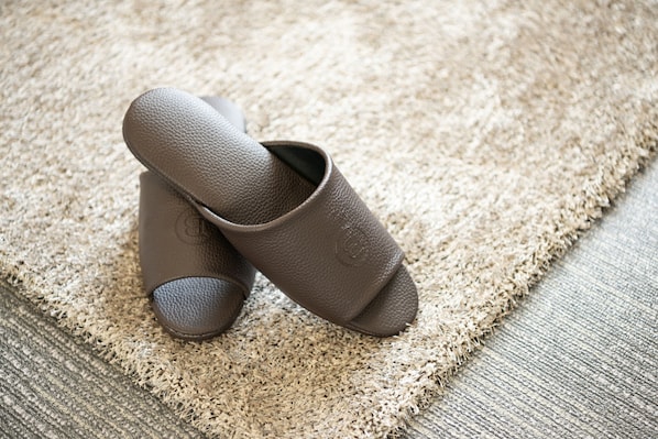 A pair of brown shoes on a textured beige carpet. - Browndot Seomyeon Business (Busan)