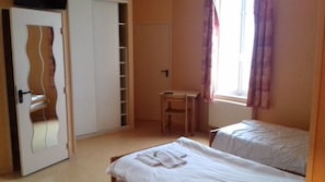 A bedroom with a bed, a desk, and a wardrobe. - Le Manoir des Tourelles (Asnelles)