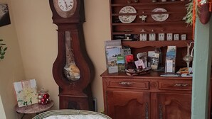 Un rincón acogedor con sillones de mimbre y un mueble de madera con platos decorativos.