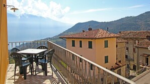 Varanda com mesa e cadeiras com vista para uma paisagem montanhosa.