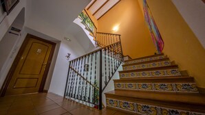 Una escalera con baldosas ornamentadas y barandilla de metal.